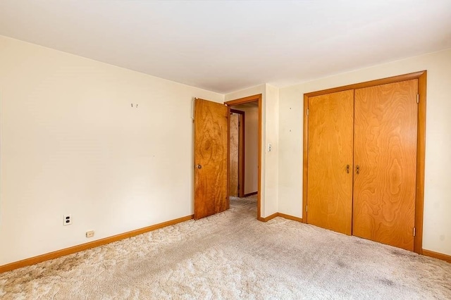 1049 Pleasant St, Canton, MA 02021 - unfurnished bedroom with baseboards, a closet, and light carpet