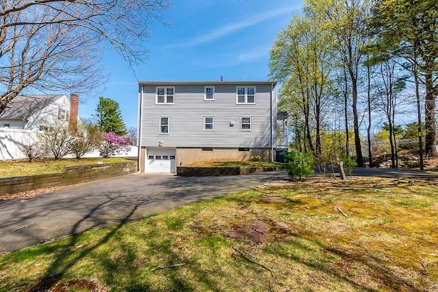 1049 Pleasant St, Canton, MA 02021 - back of house with a garage, aphalt driveway, and fence