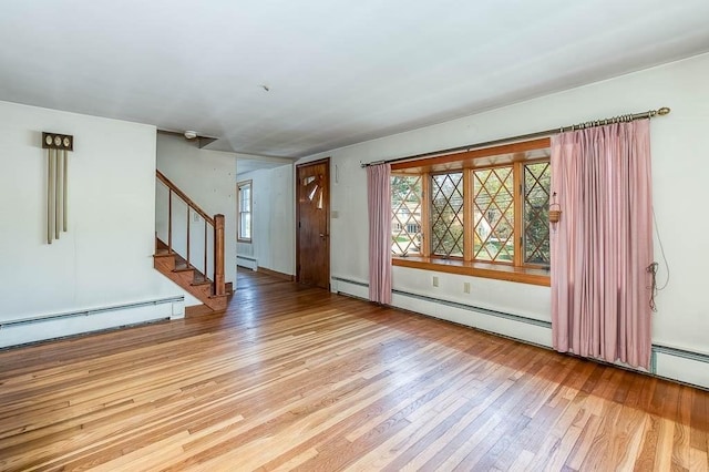 1049 Pleasant St, Canton, MA 02021 - unfurnished living room featuring a baseboard heating unit, wood finished floors, and stairway