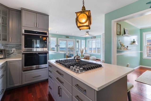 69 Leverett Ave, Revere, MA 02151 - kitchen with gray cabinets, stainless steel appliances, dark wood finished floors, light countertops, and crown molding