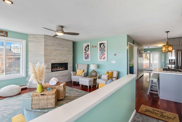 69 Leverett Ave, Revere, MA 02151 - living room featuring ceiling fan, a baseboard radiator, a tiled fireplace, and dark wood finished floors