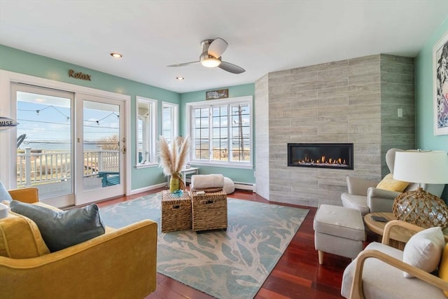 69 Leverett Ave, Revere, MA 02151 - living area featuring a baseboard heating unit, a tiled fireplace, wood finished floors, ceiling fan, and recessed lighting