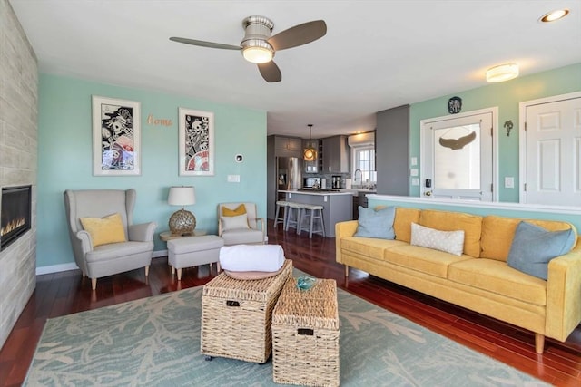 69 Leverett Ave, Revere, MA 02151 - living area with a ceiling fan, dark wood-style floors, a fireplace, and baseboards