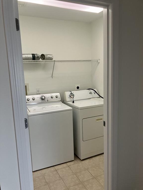 laundry room featuring laundry area, separate washer and dryer, and light tile patterned flooring