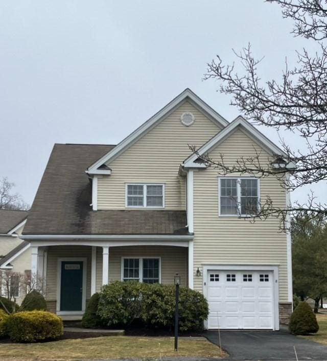 traditional-style home with a garage and aphalt driveway