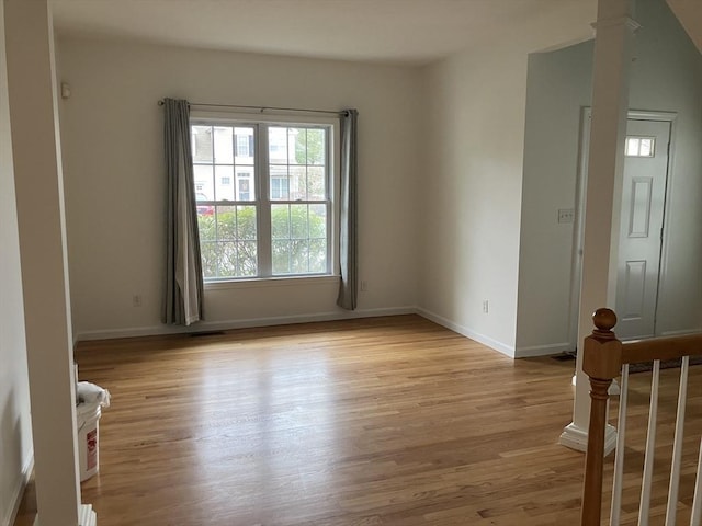 empty room featuring light wood finished floors and baseboards