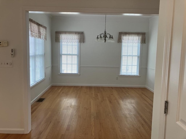 unfurnished dining area with a wealth of natural light, light wood-style flooring, visible vents, and baseboards