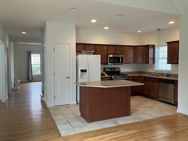 kitchen featuring stainless steel appliances, light wood-style floors, a wealth of natural light, and a kitchen island