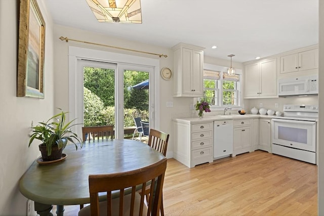 3 Roosevelt Pl, Newburyport, MA 01950 - kitchen featuring white appliances, a sink, light countertops, light wood-type flooring, and white cabinets