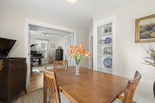 3 Roosevelt Pl, Newburyport, MA 01950 - dining area featuring ornamental molding, built in shelves, wood finished floors, a ceiling fan, and baseboards