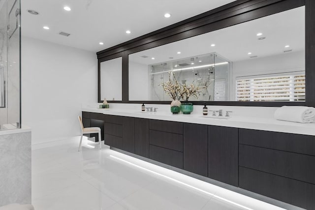 bathroom featuring a sink, double vanity, a marble finish shower, and visible vents