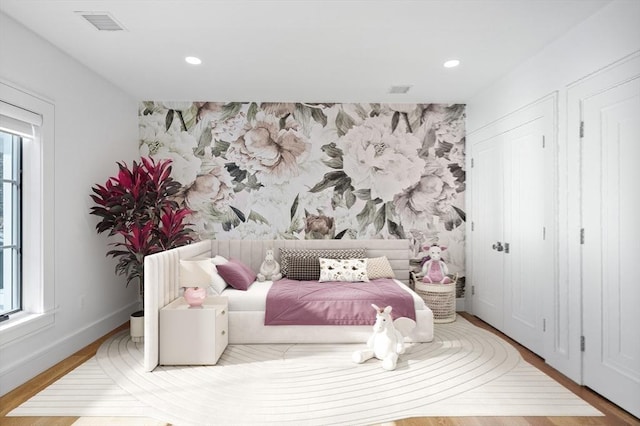 bedroom featuring baseboards, an accent wall, recessed lighting, and wallpapered walls