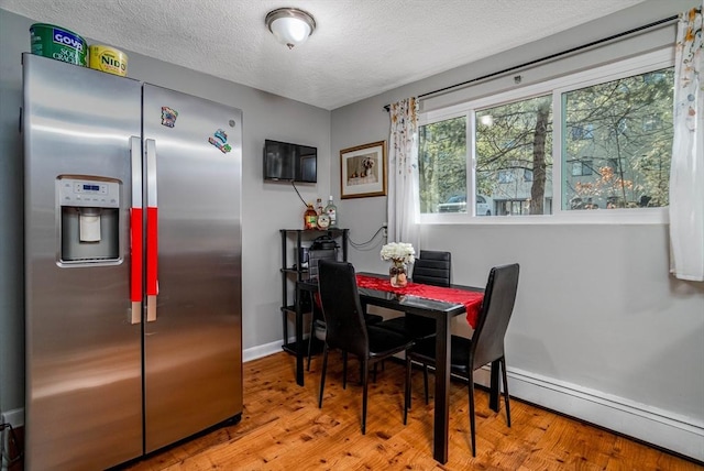 dining space featuring hardwood / wood-style flooring and a textured ceiling