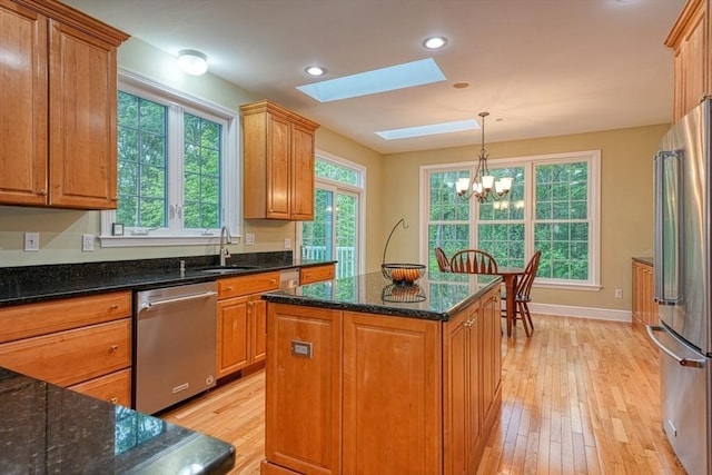 106 Willow Brook Dr Unit 106, Wayland, MA 01778 - kitchen with appliances with stainless steel finishes, a skylight, light wood finished floors, a chandelier, and brown cabinets