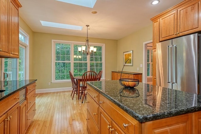 106 Willow Brook Dr Unit 106, Wayland, MA 01778 - kitchen featuring a skylight, high end refrigerator, light wood-style flooring, brown cabinetry, and a chandelier