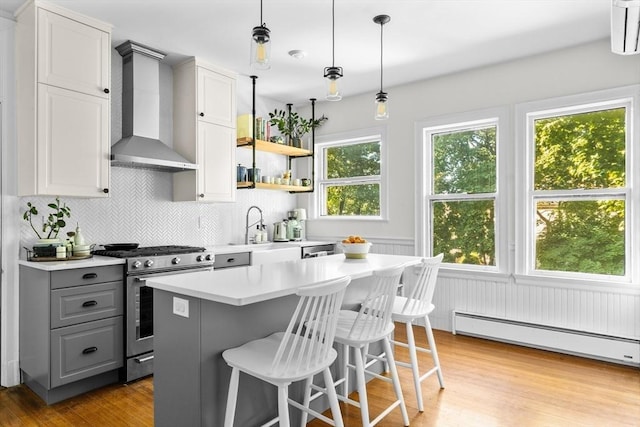 30 Welles Ave Unit 2, Boston, MA 02124 - kitchen featuring wall chimney exhaust hood, stainless steel gas stove, gray cabinets, a sink, and a baseboard heating unit