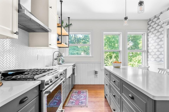30 Welles Ave Unit 2, Boston, MA 02124 - kitchen featuring gray cabinets, high end stainless steel range, wall chimney range hood, light countertops, and a wainscoted wall
