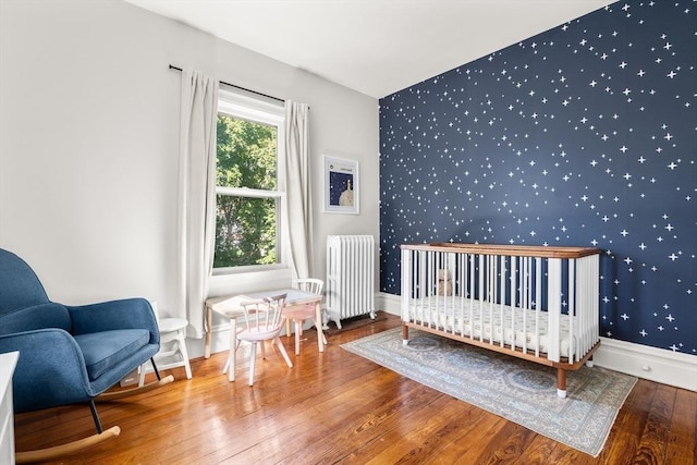 30 Welles Ave Unit 2, Boston, MA 02124 - bedroom featuring radiator, wallpapered walls, an accent wall, hardwood / wood-style floors, and baseboards