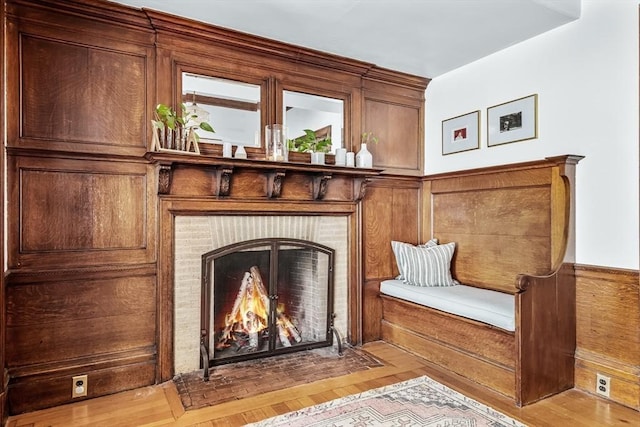 30 Welles Ave Unit 2, Boston, MA 02124 - living area with a wainscoted wall, a fireplace, light wood-type flooring, and wooden walls