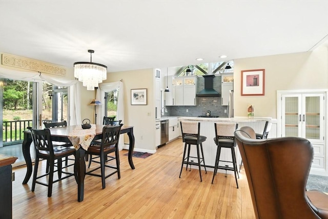 dining space featuring light wood-type flooring, recessed lighting, and an inviting chandelier