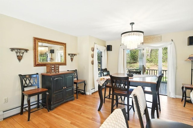 dining room featuring an inviting chandelier, a baseboard radiator, and light wood-type flooring