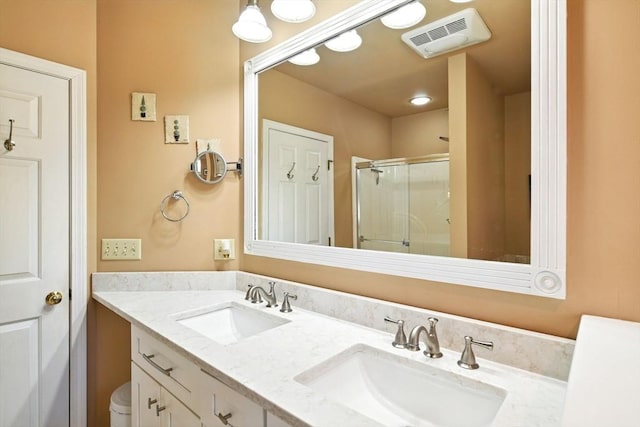 bathroom with a sink, a shower stall, double vanity, and visible vents