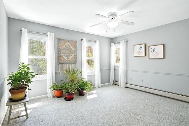 unfurnished room featuring carpet flooring, baseboard heating, ceiling fan, and a healthy amount of sunlight