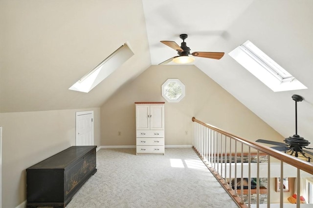 additional living space featuring ceiling fan, light carpet, baseboards, and lofted ceiling with skylight