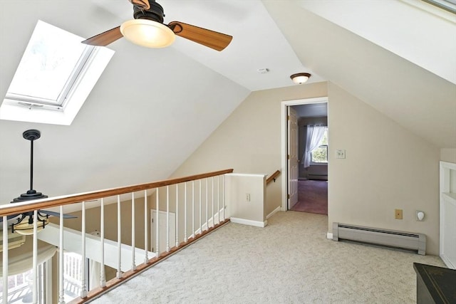 additional living space featuring ceiling fan, carpet, a baseboard heating unit, and lofted ceiling with skylight