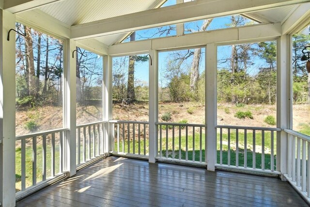 unfurnished sunroom featuring vaulted ceiling and hardwood / wood-style flooring