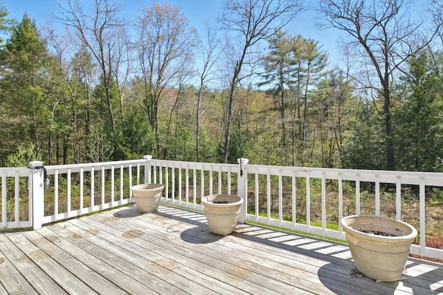 wooden deck featuring a forest view