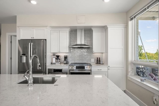 130 Broad Reach Unit 303, Weymouth, MA 02191 - kitchen with wall chimney range hood, stainless steel appliances, a sink, white cabinetry, and decorative backsplash