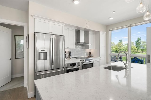 130 Broad Reach Unit 303, Weymouth, MA 02191 - kitchen with wall chimney exhaust hood, a sink, appliances with stainless steel finishes, tasteful backsplash, and light stone countertops