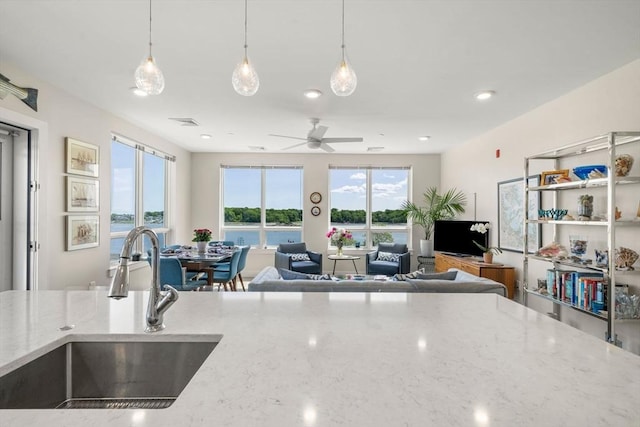 130 Broad Reach Unit 303, Weymouth, MA 02191 - kitchen with a sink, open floor plan, decorative light fixtures, light stone counters, and ceiling fan