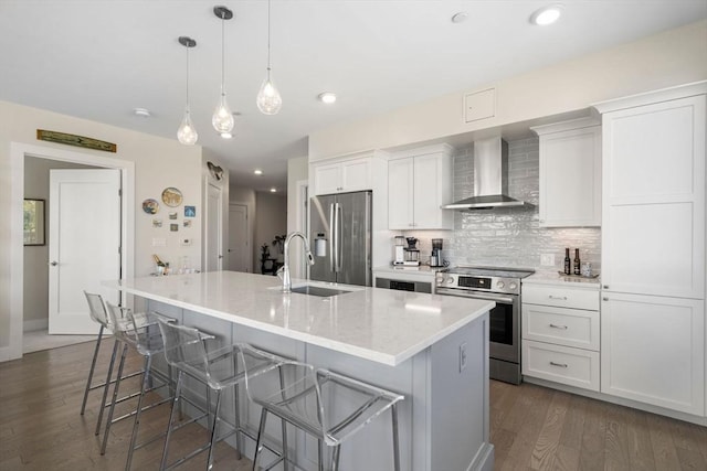 130 Broad Reach Unit 303, Weymouth, MA 02191 - kitchen with appliances with stainless steel finishes, a sink, wall chimney exhaust hood, an island with sink, and a breakfast bar