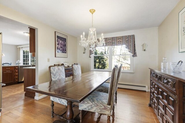 dining space featuring baseboard heating, an inviting chandelier, and light wood-style flooring