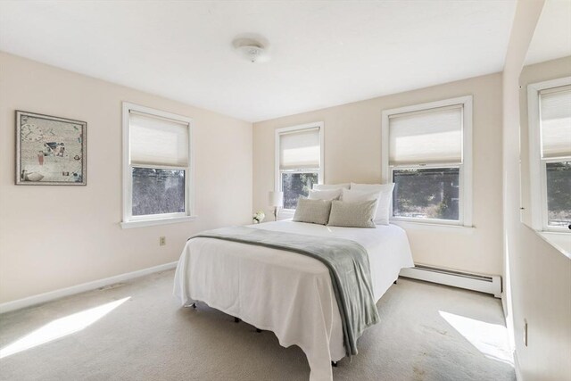 bedroom with baseboards, a baseboard heating unit, and carpet