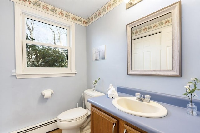 half bathroom with vanity, toilet, and a baseboard heating unit