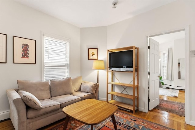 living room with a baseboard heating unit and hardwood / wood-style flooring