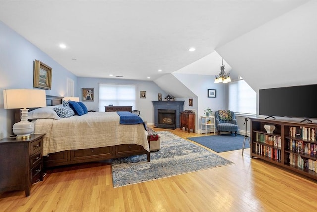 22 Flintlock Rd, Lexington, MA 02420 - bedroom featuring light wood-type flooring, a chandelier, recessed lighting, a fireplace, and vaulted ceiling