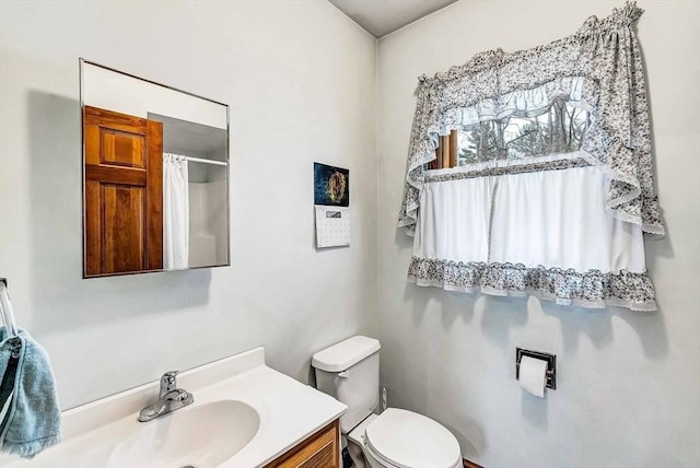 bathroom with toilet, a shower with curtain, and vanity
