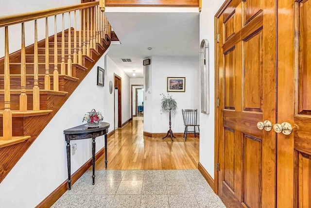 foyer entrance with granite finish floor, stairway, visible vents, and baseboards