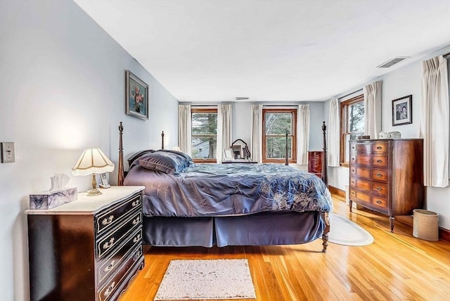 bedroom featuring light wood finished floors and visible vents