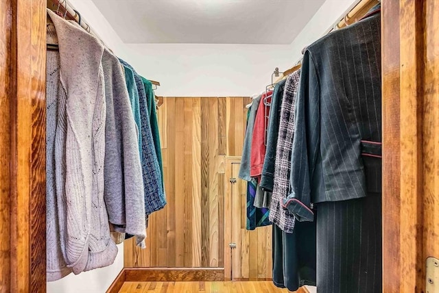 walk in closet with wood finished floors