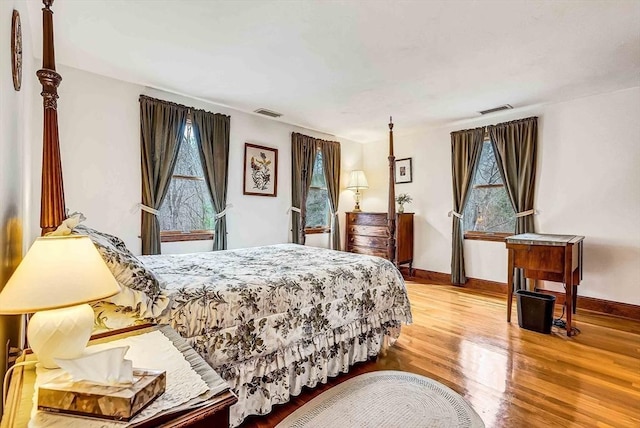 bedroom featuring visible vents, wood finished floors, and baseboards