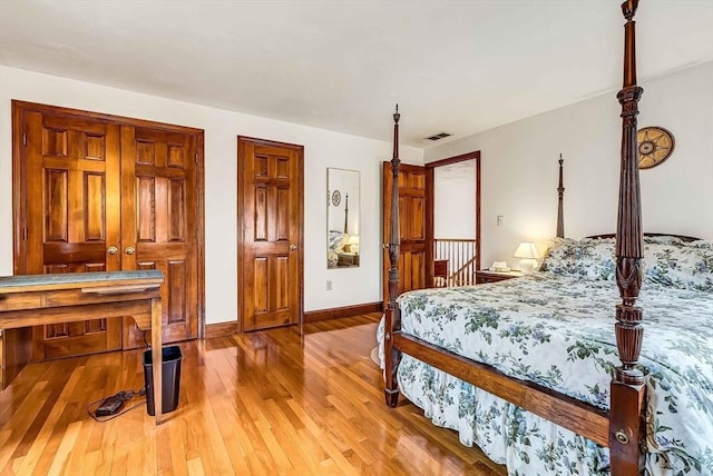 bedroom featuring visible vents, baseboards, and light wood-style floors
