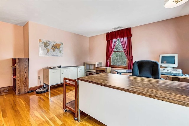 office space featuring baseboards, visible vents, and light wood-style flooring
