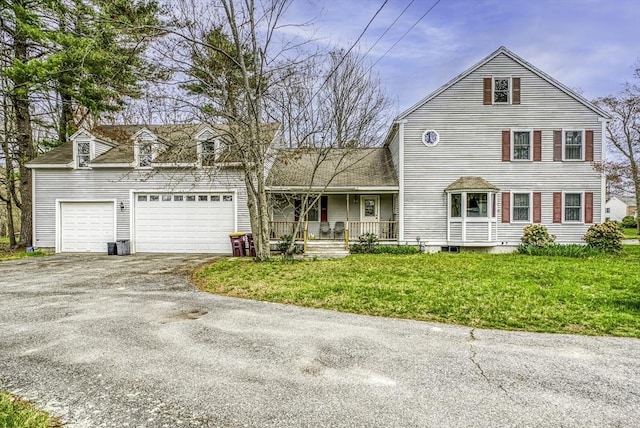 view of front of home with a porch, a front lawn, driveway, and an attached garage