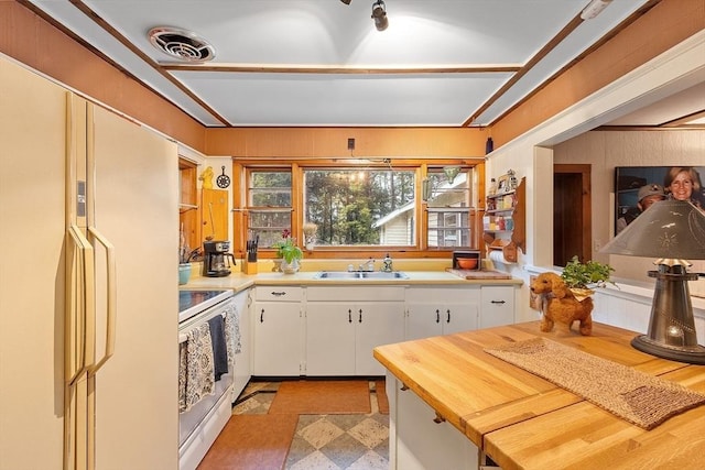 kitchen with white appliances, a sink, white cabinets, and light flooring