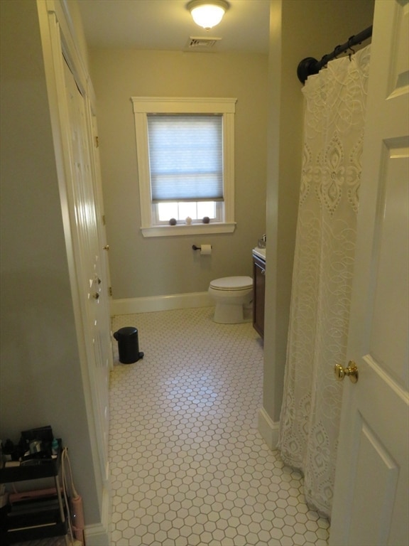 bathroom with tile patterned flooring, vanity, and toilet